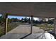 Open carport offering shaded parking and a view of the quiet, tree-lined street at 552 Trade Winds Dr, Dunedin, FL 34698