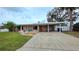 Charming single-story home with a covered carport, vibrant landscaping, and inviting curb appeal at 552 Trade Winds Dr, Dunedin, FL 34698