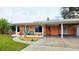 Charming single-story home featuring a vibrant exterior, covered parking, and well-maintained landscaping at 552 Trade Winds Dr, Dunedin, FL 34698