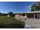 Charming single-story home featuring a vibrant exterior, covered parking, and a well-manicured lawn at 552 Trade Winds Dr, Dunedin, FL 34698