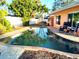 Private pool with a brick paver surround, lush landscaping, and inviting lounge chairs at 552 Trade Winds Dr, Dunedin, FL 34698