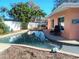 Large, clean pool in the back with lounge seating and lush landscaping at 552 Trade Winds Dr, Dunedin, FL 34698