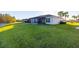 Home features a screened patio, lush lawn, and pond view at 10306 Chatuge Dr, San Antonio, FL 33576