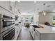 Modern kitchen with white cabinets, stainless steel appliances, and a large island at 10551 Tranquil Meadow Loop, Riverview, FL 33569