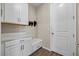 Bright laundry room with white cabinets and built-in bench at 10551 Tranquil Meadow Loop, Riverview, FL 33569
