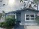 Gray house with teal front door, landscaping, and a partially visible driveway at 1818 Shore Acres Ne Blvd, St Petersburg, FL 33703