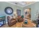 The living room features comfortable leather chairs and a large decorative clock, adjacent to the dining area and open kitchen at 5608 Tidewater Preserve Blvd, Bradenton, FL 34208