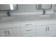 Bathroom features dual vanity with modern fixtures, framed mirrors, and white cabinets at 103 2Nd Ne Ave, Lutz, FL 33549