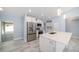 Modern kitchen featuring white cabinets, stainless steel appliances, and a large island at 103 2Nd Ne Ave, Lutz, FL 33549