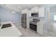 Bright kitchen featuring stainless steel appliances, a stylish faucet, and modern white cabinetry at 103 2Nd Ne Ave, Lutz, FL 33549