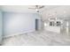 Open-concept living space leading to a bright kitchen with white cabinetry and stainless steel appliances at 103 2Nd Ne Ave, Lutz, FL 33549