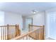 Upstairs hallway with wood railing and neutral walls at 10816 Lakeside Vista Dr, Riverview, FL 33569