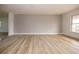 Spacious living room featuring light gray walls and wood-look tile floors at 1505 New Bedford Dr, Sun City Center, FL 33573