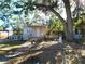 Tan house with white trim, ramp, and mature trees in the front yard at 1708 Preston S St, St Petersburg, FL 33712