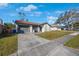 House exterior showcasing a driveway, landscaping, and a two-car garage at 1722 W Groveleaf Ave, Palm Harbor, FL 34683