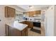 L-shaped kitchen with ample counter space and wood cabinets at 1722 W Groveleaf Ave, Palm Harbor, FL 34683