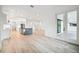 Open living room and kitchen area with light wood flooring and French doors at 19504 Sheltered Hill Dr, Brooksville, FL 34601