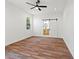 Bright bedroom featuring a ceiling fan, wood-look flooring, barn door and access to bathroom at 2503 E 19Th Ave, Tampa, FL 33605