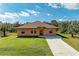 Front view of a single-story house with a brown roof and light orange exterior at 397 Doniphan Dr, Port Charlotte, FL 33954