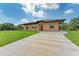 Tan house with a brown roof, driveway, and grassy lawn at 397 Doniphan Dr, Port Charlotte, FL 33954