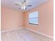 Simple bedroom with light peach walls, ceiling fan, and wood-look tile flooring at 397 Doniphan Dr, Port Charlotte, FL 33954