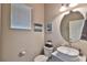 Clean bathroom with an oval mirror, pedestal sink, and updated fixtures at 6912 Makers Way, Apollo Beach, FL 33572