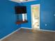 Bedroom with light wood flooring and blue walls at 1291 S Disston Ave, Tarpon Springs, FL 34689