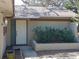 Home's entrance with a white door and landscaping at 1291 S Disston Ave, Tarpon Springs, FL 34689