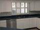 Kitchen with dark countertops, stainless steel dishwasher and sink at 1291 S Disston Ave, Tarpon Springs, FL 34689