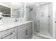 Bathroom with gray vanity, frameless shower, and marble tile at 1390 Gulf Blvd # 1204, Clearwater, FL 33767