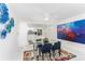 Bright dining room with glass table, blue chairs, and modern art at 1390 Gulf Blvd # 1204, Clearwater, FL 33767