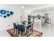 Bright dining room with glass table, blue chairs, and modern art at 1390 Gulf Blvd # 1204, Clearwater, FL 33767
