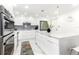 Modern white kitchen with stainless steel appliances and a large island at 1390 Gulf Blvd # 1204, Clearwater, FL 33767