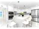 Modern white kitchen with stainless steel appliances and a large island at 1390 Gulf Blvd # 1204, Clearwater, FL 33767