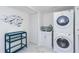 White laundry room with a utility sink and stackable washer/dryer at 1390 Gulf Blvd # 1204, Clearwater, FL 33767