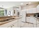 Bright kitchen featuring double sinks, ample counter space, and white cabinets at 1687 Starling Drive, Tarpon Springs, FL 34689