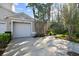 Two-car garage with driveway and lush landscaping at 1687 Starling Drive, Tarpon Springs, FL 34689