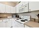 Kitchen features white cabinets, a gas range, and a built-in microwave at 1687 Starling Drive, Tarpon Springs, FL 34689