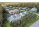 Aerial view of community featuring townhouses, roads, and lush greenery at 1687 Starling Drive, Tarpon Springs, FL 34689