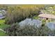 Aerial view of townhouses nestled in a wooded area with additional buildings visible at 1687 Starling Drive, Tarpon Springs, FL 34689