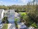 Two-story tan house with attached garage and surrounding trees at 1687 Starling Drive, Tarpon Springs, FL 34689