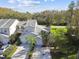 Two-story tan house with attached garage and surrounding trees at 1687 Starling Drive, Tarpon Springs, FL 34689