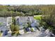 Two-story tan house with attached garage and surrounding trees at 1687 Starling Drive, Tarpon Springs, FL 34689