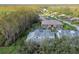 Aerial view showcasing townhouses and surrounding landscape, including a road and trees at 1687 Starling Drive, Tarpon Springs, FL 34689