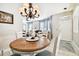 Dining room with round table and chandelier, view to living room at 1687 Starling Drive, Tarpon Springs, FL 34689