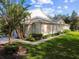 Tan house with attached garage and neatly landscaped yard at 1687 Starling Drive, Tarpon Springs, FL 34689