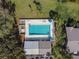 Community pool with surrounding patio furniture and lush landscaping at 1687 Starling Drive, Tarpon Springs, FL 34689