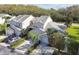 Two-story tan house with attached garage and surrounding trees at 1687 Starling Drive, Tarpon Springs, FL 34689