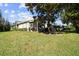 Tan house with screened porch and lush green lawn at 1687 Starling Drive, Tarpon Springs, FL 34689