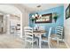 Dining area with round table, white chairs, and blue accent wall at 1687 Starling Drive, Tarpon Springs, FL 34689